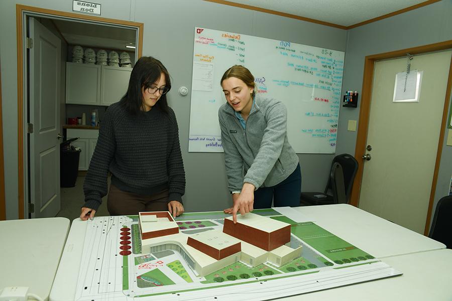 ${ Students working with a model of the Roger Glass Center for the Arts }